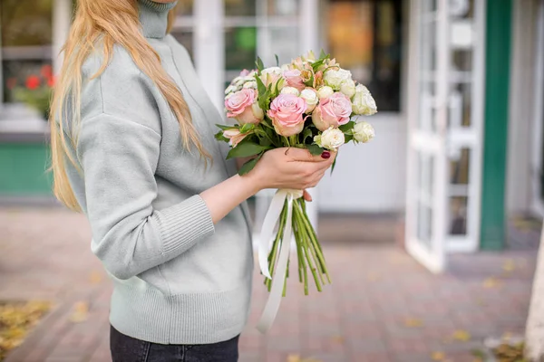 Florista loja à luz do dia. Uma mulher tem um lindo buquê de flores. Florista com o seu trabalho. Foto concurso estilizado — Fotografia de Stock