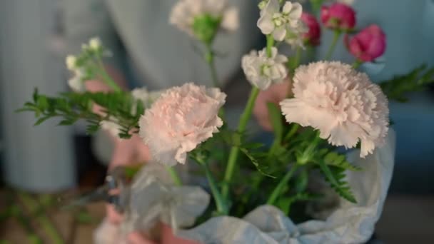 Jobbar i blomsteraffär. Professionell florist skapar stora vackra bukett av färska vita rosor, gula liljor och gröna blad. — Stockvideo