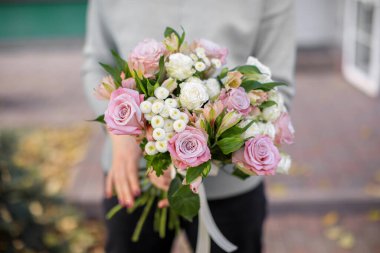 Güzel, taze bir buket. Çiçek teslimatı. Kadın çiçekçi. Güzel bir buket karışık çiçek. Çiçek dükkanı konsepti