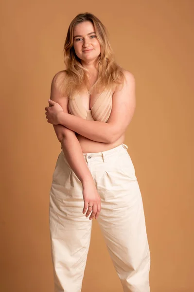 Hermosa mujer con sobrepeso en traje de baño beige sobre fondo rosa — Foto de Stock