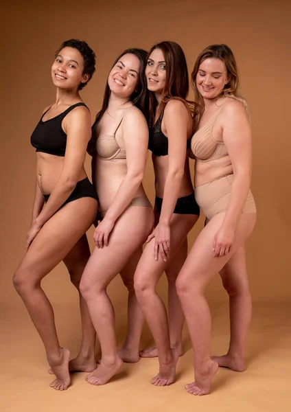 Belles filles grasses en lingerie noire sur fond rose. Concept positif pour le corps. Groupe de femmes dont le corps et l'origine ethnique sont différents — Photo