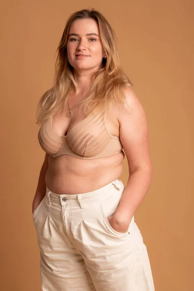 Bella donna in sovrappeso in costume da bagno beige su sfondo rosa — Foto Stock
