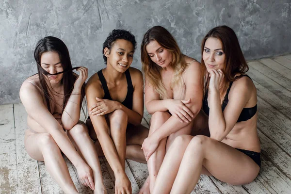 Arkadaşlık, güzellik, vücut pozitifliği ve insanların konsepti. İç çamaşırlarıyla gri arka plan üzerinde farklı kadınlar grubu. — Stok fotoğraf