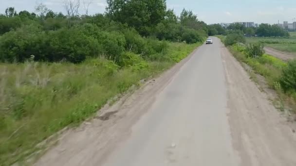 Coche plateado está conduciendo a lo largo de la carretera. Día de verano . — Vídeo de stock