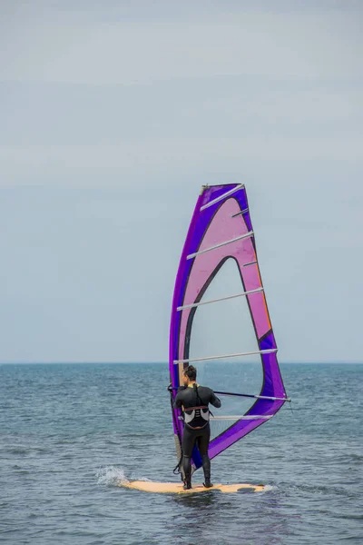 A windsurfer rides on the sea in calm, light wind. The view from the back. Anapa, Russia, Black sea