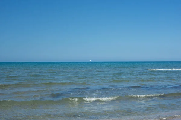 Il cielo azzurro sul mare calmo con il riflesso della luce solare. Calma armonia del mare di superficie dell'acqua calma. Cielo soleggiato e oceano blu calmo . — Foto Stock