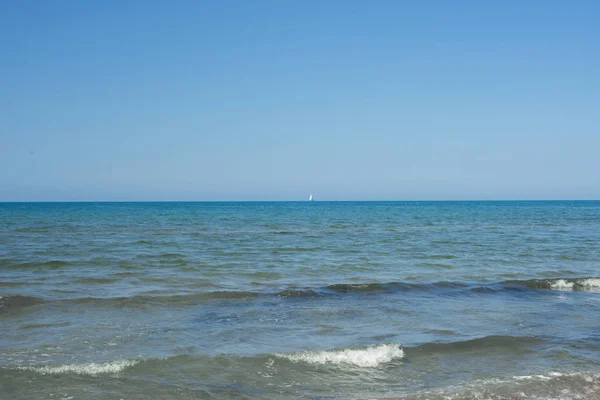 Il cielo azzurro sul mare calmo con il riflesso della luce solare. Calma armonia del mare di superficie dell'acqua calma. Cielo soleggiato e oceano blu calmo . — Foto Stock