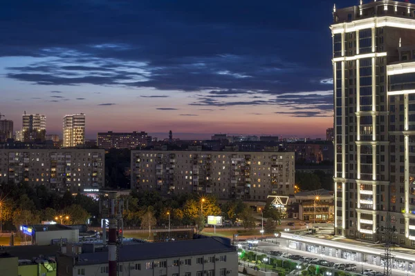 Krasnodar, Rusia - 29 de junio de 2019: hermosa fachada del edificio contra el cielo nocturno con puesta de sol.Vista de la calle Turgenev. Nuevo rascacielos residencial de arquitectura renacentista. Camino nocturno en — Foto de Stock