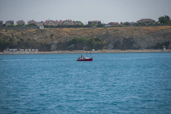 Anapa, Rusia - 17 de junio de 2019: Vista panorámica de la costa del mar con un barco rojo. En la bahía izquierda, a la derecha el mar. Mar Negro, Supseh, Anapa, región de Krasnodar . —  Fotos de Stock