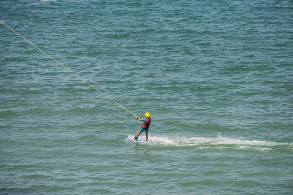 Wakeboard. Adatto wakeboarder attraente guardando dritto davanti mentre cavalca sulla superficie dell'acqua — Foto Stock