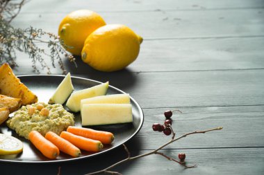 Sağlıklı ev yapımı humus çeşitli taze sebze ve limon ile
