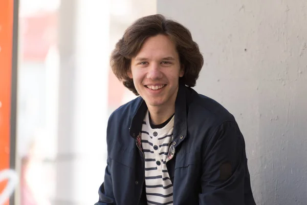 Joven Hombre Sonriente Sentado Mirando Cámara Fotos De Stock Sin Royalties Gratis