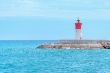 Denizdeki deniz feneri ve ufuktaki temiz bir çizgi İspanya 'daki Cartagena şehri.