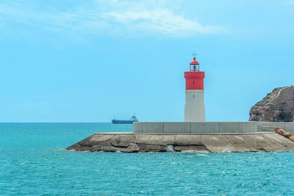 Denizde kırmızı ve beyaz deniz feneri ufukta, İspanya 'nın Cartagena şehrinin yakınlarında..