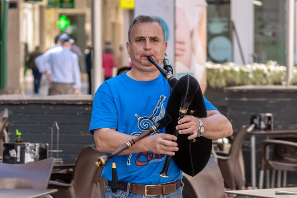4 Mayıs 2019 'da Cartagena, İspanya' da düzenlenen Mayıs Haç Festivali 'nde bir adam sokakta gayda çalıyor.
