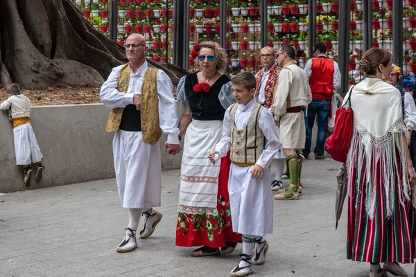 23 Nisan 2019 tarihinde İspanya 'nın Murcia kentinde düzenlenen Bando de la Huerta bahar festivali sırasında geleneksel tatil köylüleri (huertano) kıyafetleriyle meydanda yürüyen bir aile..