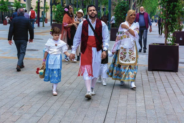22 Nisan 2019 'da İspanya' nın Murcia kentinde düzenlenen Bando de la Huerta bahar festivali sırasında sokakta yürüyen geleneksel, güzel kıyafetli bir aile..