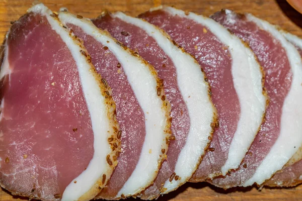 Carne salada rebanada en una tabla de madera con pepinos salados —  Fotos de Stock