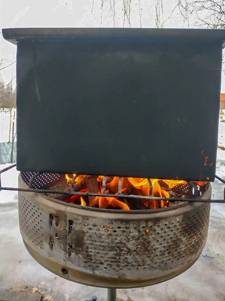 Ved som förbränningen i en brand som värmer upp en grill — Stockfoto
