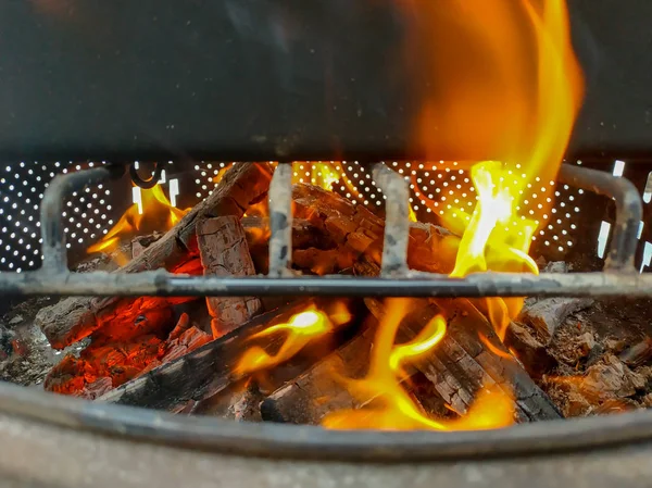 Firewood burning in a fire warming up a barbecue — Stock Photo, Image