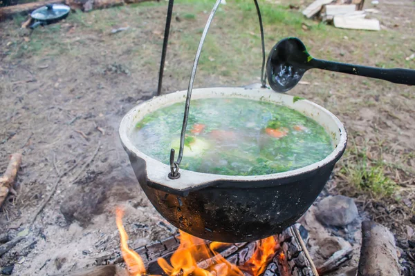 Supă de pește gătit într-o oală pe un foc în pădure de lângă mare — Fotografie, imagine de stoc