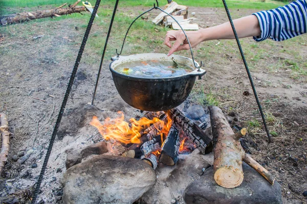 Sopa de peixe cozinhar em uma panela em um fogo na floresta junto ao mar Imagens De Bancos De Imagens Sem Royalties