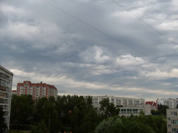 Gri Cumulus Bulutları Düşük Yüksek Binalar Yeşil Ağaçlar Üzerinde — Stok fotoğraf