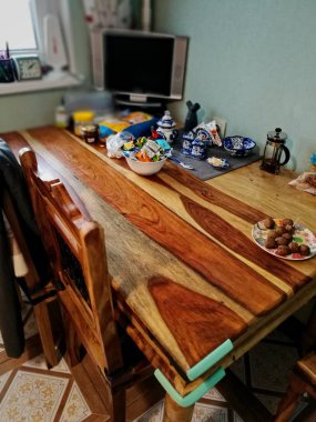 Mutfak iç ahşap masa ve sandalyeler ile Tv köşesi ve mutfak eşyaları üstünde o ile