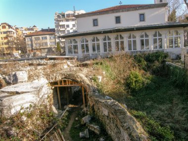 Modern yüksek katlı binalar arka planı zemin seviyesinin altında Antik taş Harabeleri