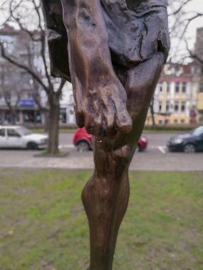 Şehrin ortasında bir metal heykel parmak ucunda asılı yağmur damlaları