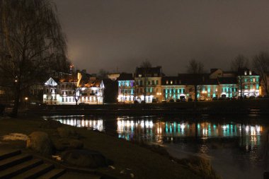 Gece şehir ışıkları buzun ince kabuğu ile göle yansıyan