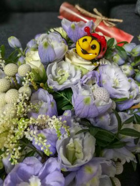 Taze çiçek leylak-mavi buket oturan sarı namlu ile cam uğur böceği