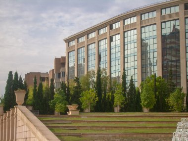 büyük cam Pencereler ile yeşil çalılar bina arkasında çim ile büyümüş merdivenlerin üst kısmında