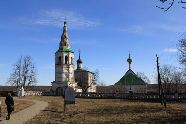 Mavi gökyüzü ve sarı biçilmiş çim karşı düşük bir çit arkasında bir çan kulesi ile eski tek kubbeli beyaz Kilise topraklarına giden taş yol