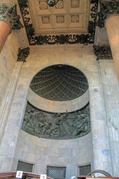 Yuvarlak bir kubbe ve sütunlar tarafından desteklenen siyah taş oyma sahneleri ile binanın içinde taş kemer