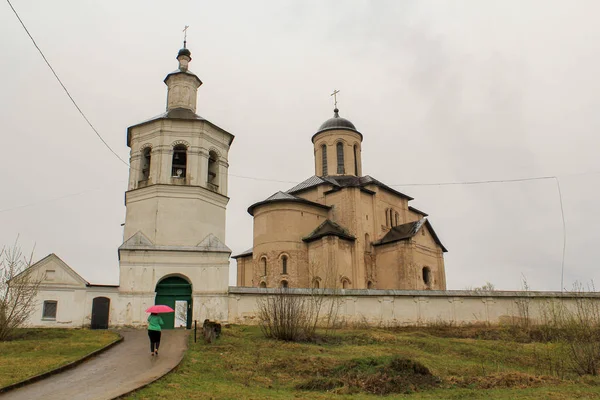 Sedilmiş çim ile gri gökyüzü ve toprak arka plan üzerinde giriş kapısının üzerinde beyaz bir çan kulesi ile tek kubbeli taş Kilise bej