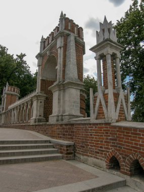 The staircase leading up is surrounded by an openwork wall of red and white brick with arches and turrets
