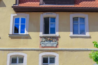 Eski taş binanın pencereleri pencerenin altında sıva ve üst bir yazıt ile sarı