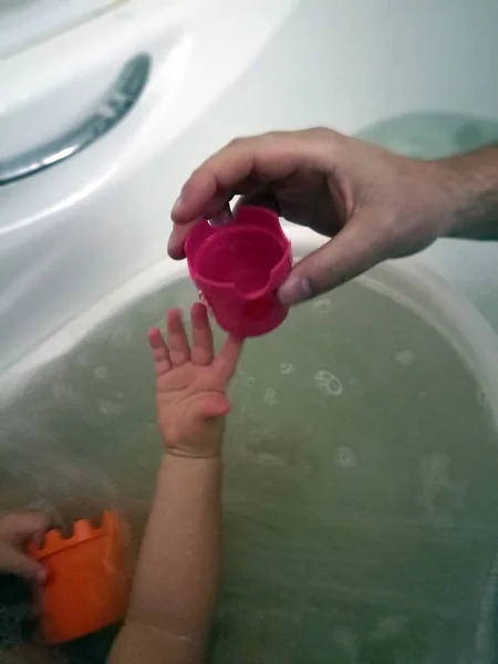 Närbild Barns Och Mäns Händer Vidrör Rosa Leksak Badet — Stockfoto