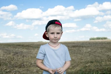 Gökyüzüne karşı tarlada tatlı bir çocuk. Mutluluk ve çocukluk kavramı