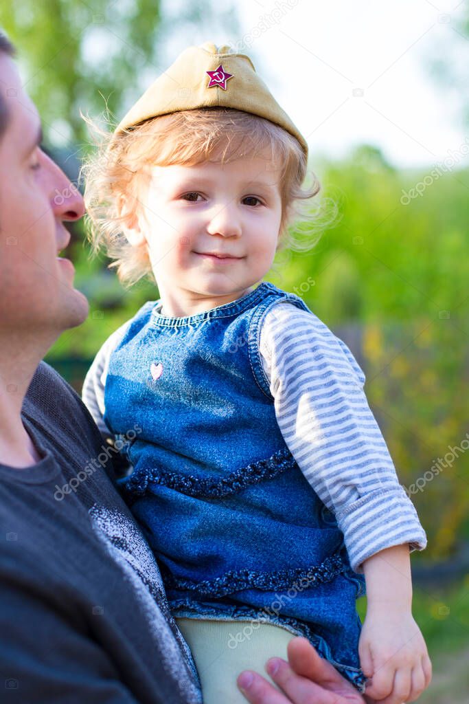 Cute girl and father are happy together, show love and care. Life style family spending time outdoors, Russia/Victory day