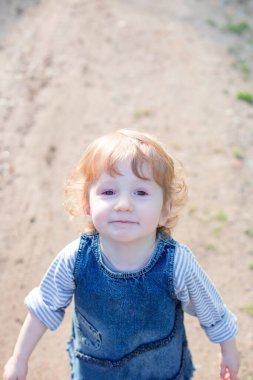 Sevimli komik kız kırsalda eğleniyor. Açık hava eğlencesi, aile zamanı ve çocukluk kavramı.