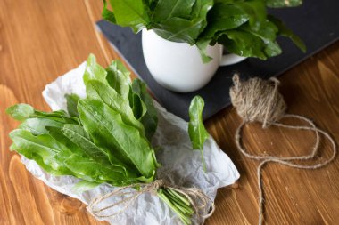 Taze organik doru, yeşil sebze çorbası ve salata için ahşap masada ıspanak tohumu. Çiğ kuş, yeşil sebze arka planını terk eder. Bahar yeşili sebzeler - doru ıspanak