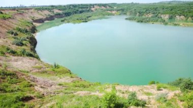  Kum çıkarma. Çamur ocağı, çamurlu sahil ağaçlarla çevrili..