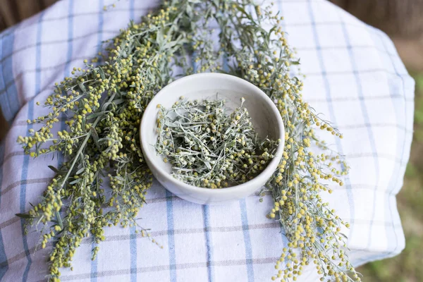 Bir demet taze kurt otu, seçici odaklanma. Baharat için harçla öğütülmüş mugwort tıbbi bir tentür hazırlar.