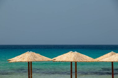 Milos adasında plajda Şemsiyeler