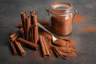 Aromalı Toz tarçın ve gri arka plan üzerinde sopa ile kompozisyon