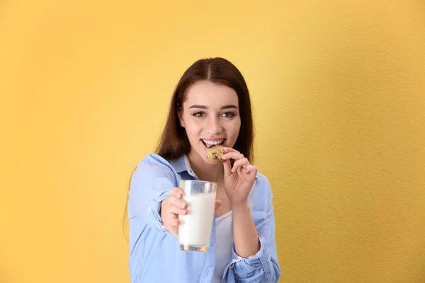 Όμορφη Νεαρή Γυναίκα Που Πίνει Γάλα Cookie Έγχρωμο Φόντο — Φωτογραφία Αρχείου