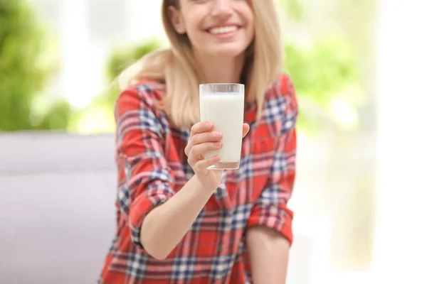 年轻漂亮的女人在家里喝牛奶 — 图库照片