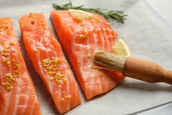 Fresh salmon with mustard on parchment, closeup